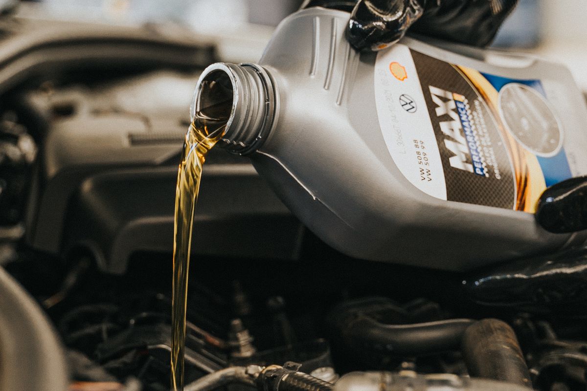 Mecânico fazendo a troca de óleo do motor de um carro na Biguá Pneus Auto Center